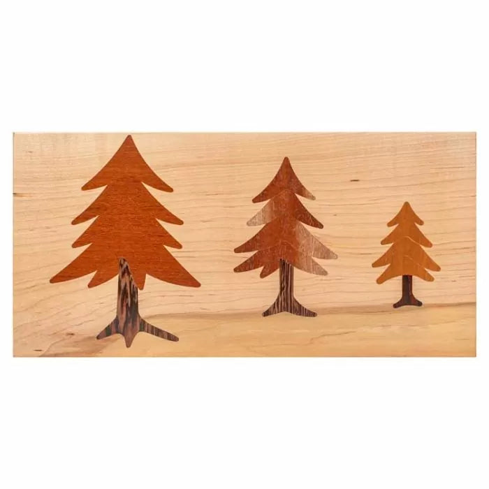 Wood inlay project with three tree silhouettes on light wood background, woodworking example