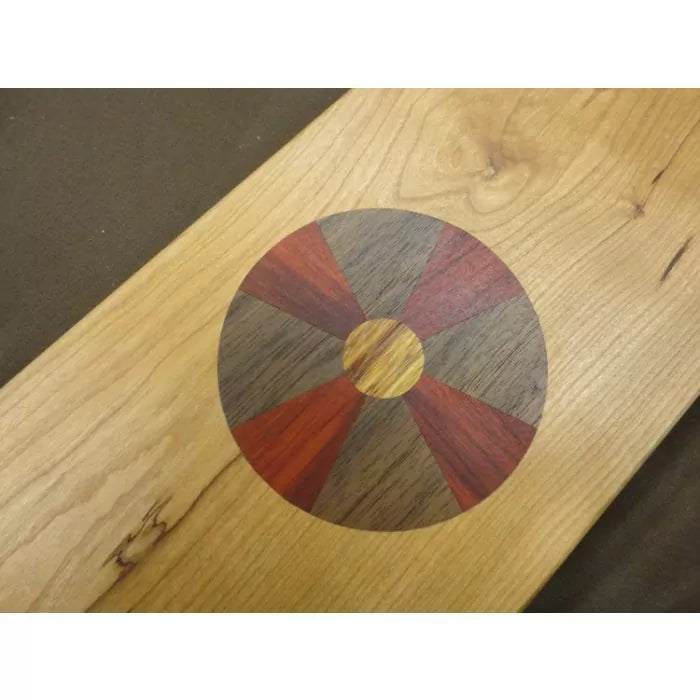 Wood inlay pattern with segmented circle on a light hardwood board, woodworking detail