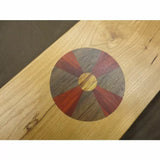 Wood inlay pattern with segmented circle on a light hardwood board, woodworking detail