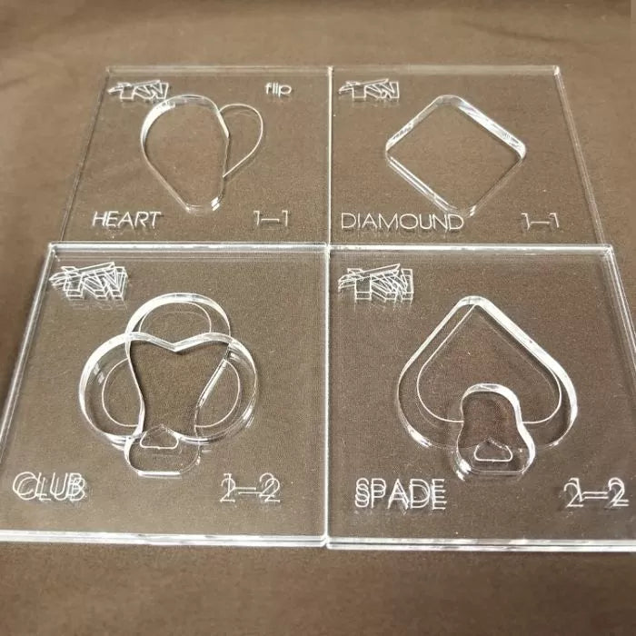 Clear acrylic woodworking templates for heart, diamond, club, and spade shapes on display.