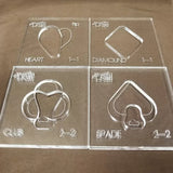 Clear acrylic woodworking templates for heart, diamond, club, and spade shapes on display.