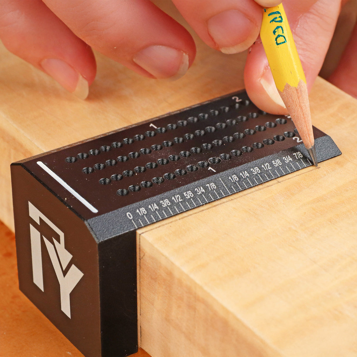 Woodworker using a precision marking gauge to mark measurements on wood