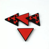 Set of red and black non-slip triangular woodworker bench dogs on white background