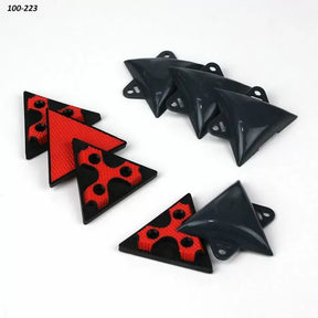 Set of red and black plastic triangle woodworking bench dogs and corner jigs on white background