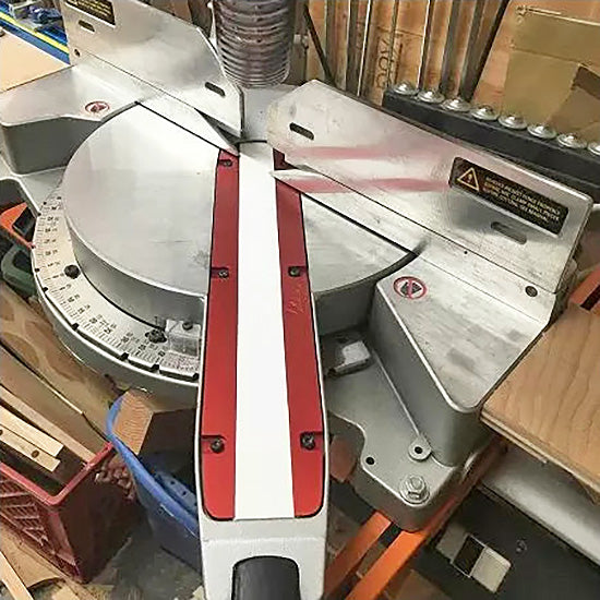 Miter saw with red and white fence system in a woodworking shop, precision cutting tool