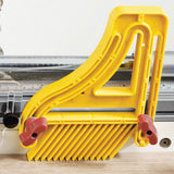 Yellow plastic table saw featherboard mounted on a saw fence for woodworking safety