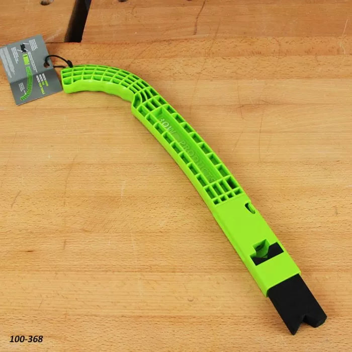 Green plastic woodworking push stick with angled handle on a wooden workbench