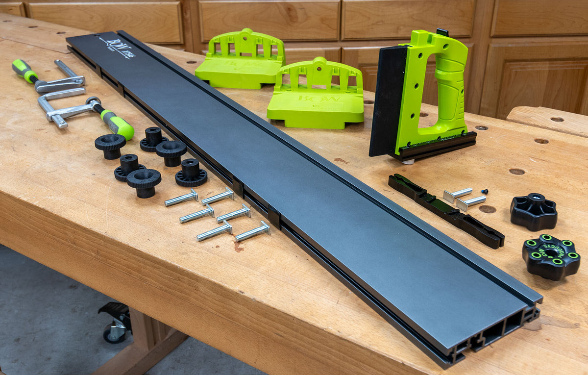 Bow Tools featherboard kit, aluminum track, clamping knobs, and accessories on woodworking bench