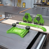Green woodworking featherboards and push block set on table saw in workshop