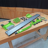 Woodworking featherboard and fence kit with green components laid out on a workbench