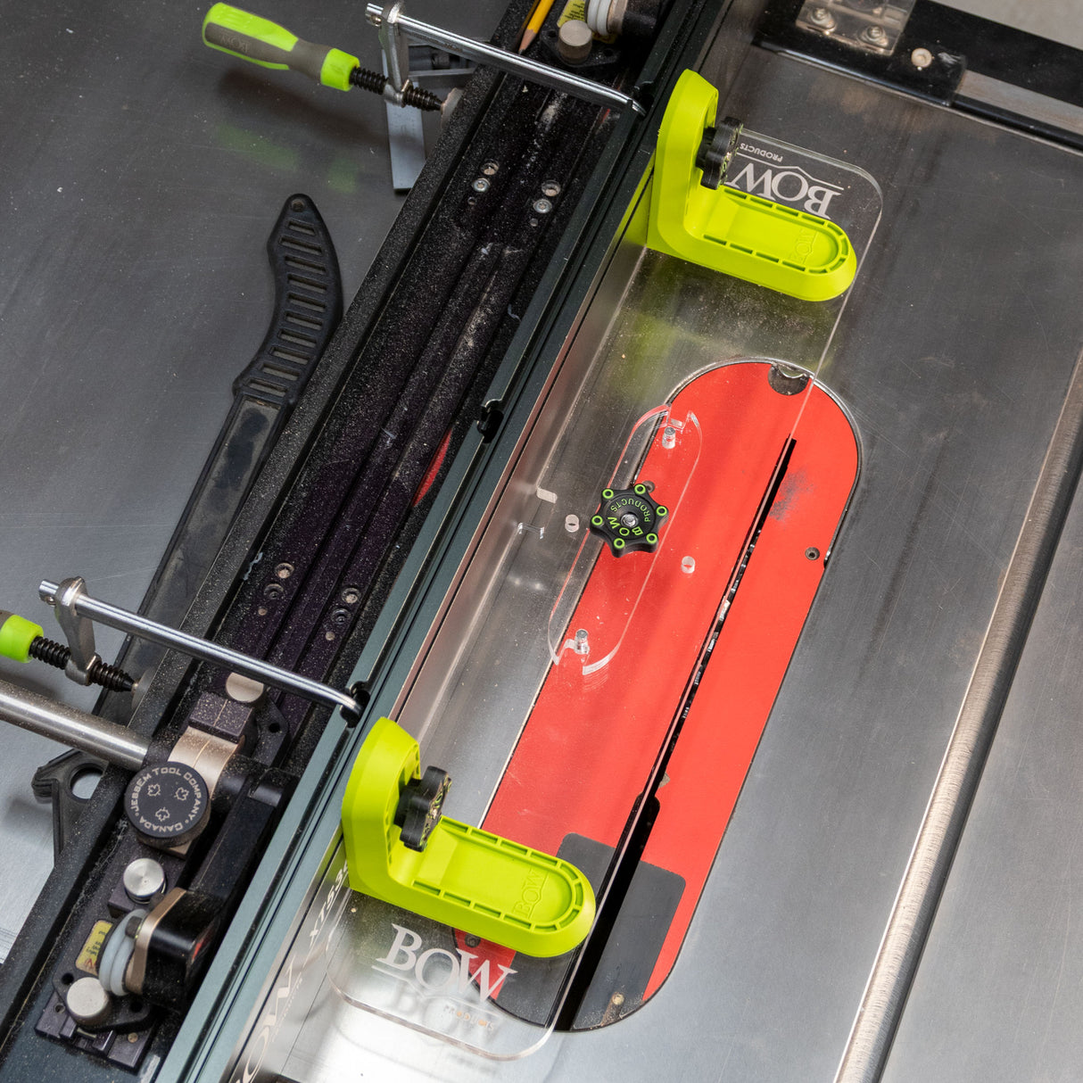 Table saw with green adjustable fence system and red saw blade for precise woodworking cuts