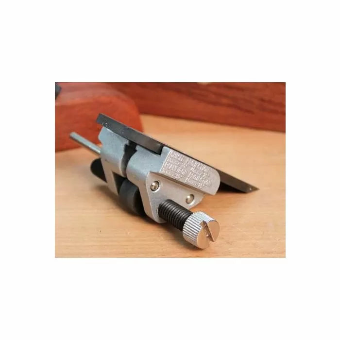Woodworking honing guide tool for sharpening chisels and plane blades on a wooden surface