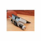 Woodworking honing guide tool for sharpening chisels and plane blades on a wooden surface