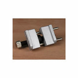 Small metal honing guide for woodworking tools on a wooden surface