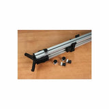 Aluminum woodworking track fence with adjustment knobs and mounting hardware on a wood surface