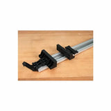 Aluminum woodworking clamp guide rail with black plastic fittings on a wood surface