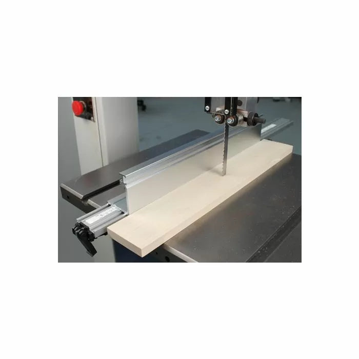 Bandsaw with aluminum fence cutting a wooden board in a woodworking shop