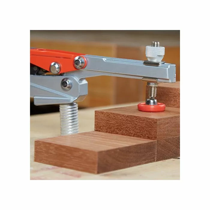 Toggle clamp securing stacked wood blocks on a woodworking bench for precise cutting