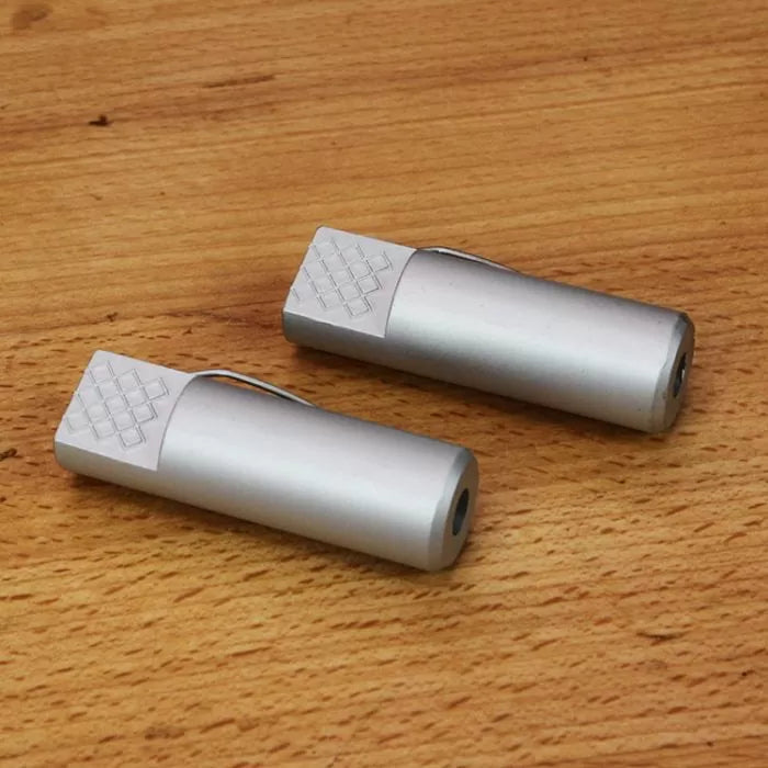 Pair of aluminum bench dogs for woodworking clamped on a wooden workbench surface.