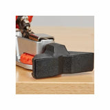 Close-up of woodworking toggle clamp with black rubber foot on a wooden surface