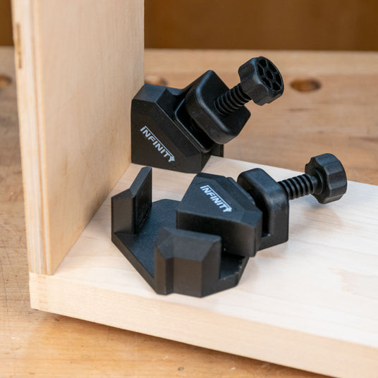 Corner clamps securing wood boards at a right angle on a workbench