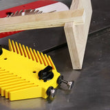Yellow featherboard and wood on table saw for woodworking precision