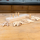 Wooden pegs and a wooden block on a wooden table with a workshop background