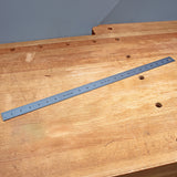 Steel metric ruler on a wooden workbench, ideal for woodworking measurement and layout