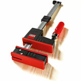Woodworking parallel jaw clamp with red handle and large clamping jaws on wood surface