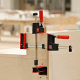 Parallel bar clamps securing wooden panels during woodworking assembly