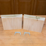 Two pinch dogs for woodworking, shown with two wood blocks on a workbench