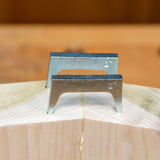 Pair of metal pinch dogs clamping hardwood joint for woodworking precision