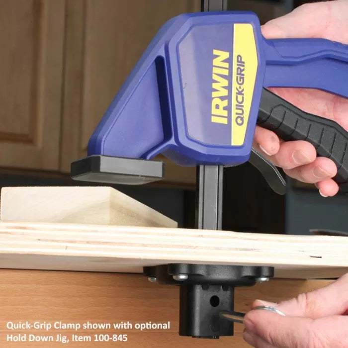 Quick-Grip clamp securing wood on workbench with hold down jig attachment, woodworking tool