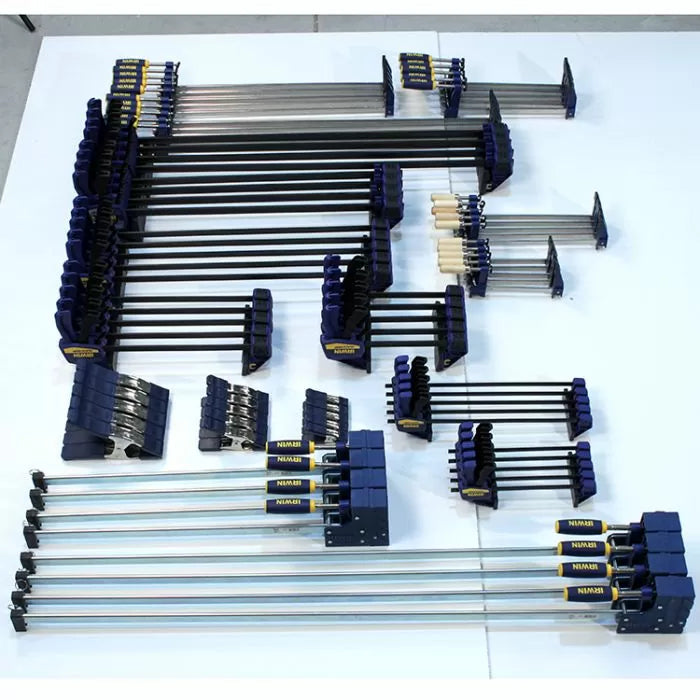Assorted woodworking clamps of various sizes organized on a white surface.