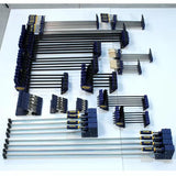 Assorted woodworking clamps of various sizes organized on a white surface.