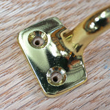 Close-up of brass hardware bracket mounted on finished wood surface for woodworking projects