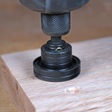 Close-up of a drill-mounted dowel jig aligning on a piece of wood for precise woodworking.