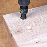 Pocket hole drill bit drilling angled holes in a wooden board for woodworking joinery.