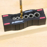 Woodworking drill guide block with drill bit in use on a wooden board