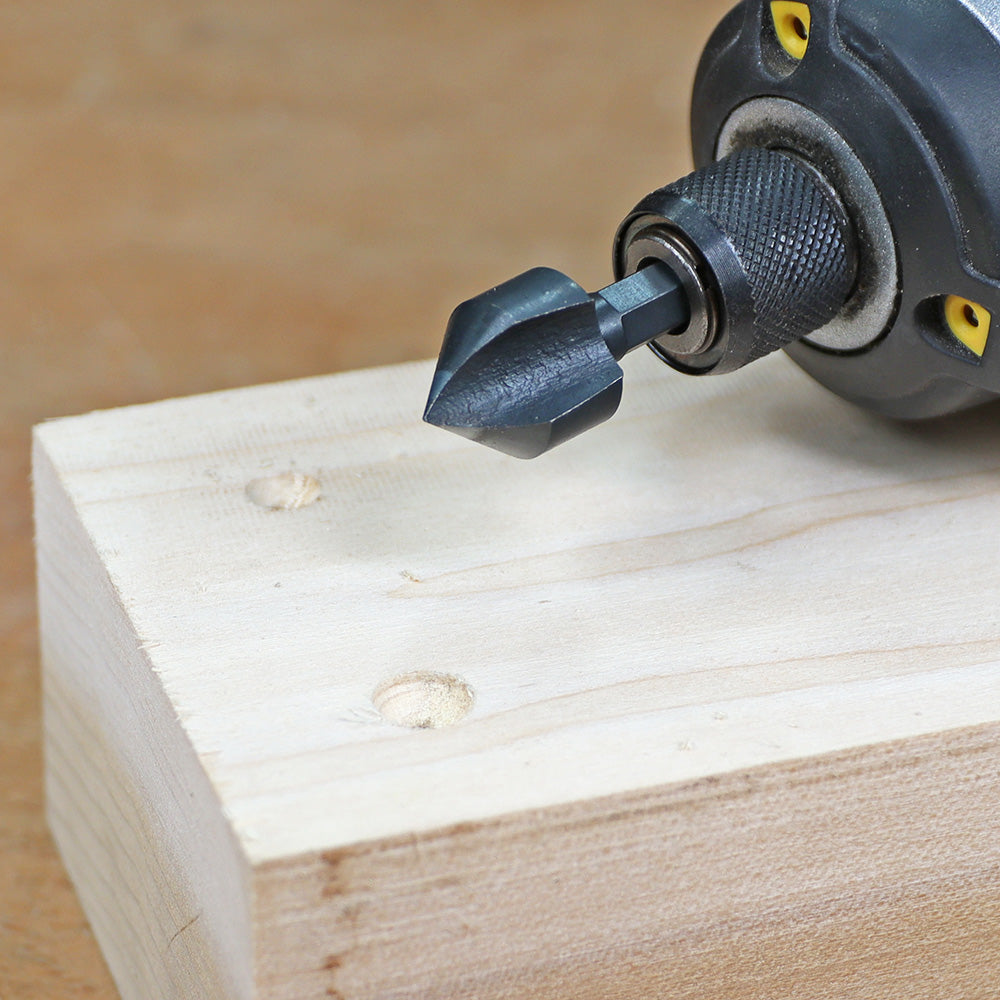 Countersink drill bit for woodworking shown on power drill with drilled wood block