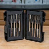 Thread tap set with metal taps in a black protective case on a woodworking bench.