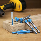 Set of blue carbide-tipped Forstner drill bits on wood block, cordless drill in background