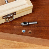 Woodworking countersink drill bit on wood surface next to screw and wooden storage box