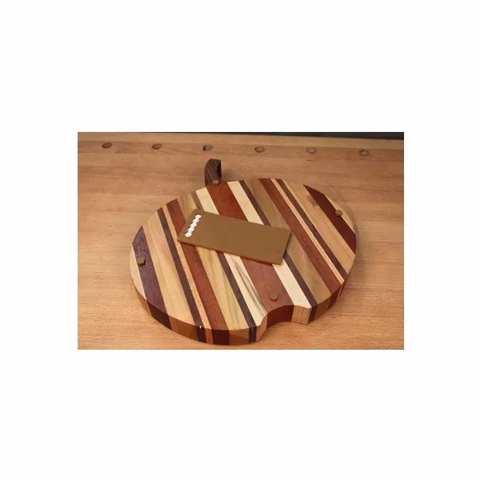 Round striped wood cutting board with handle and rectangular scraper on workbench