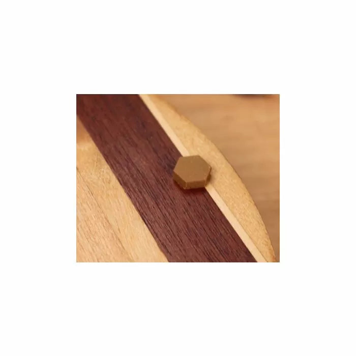 Hexagonal wood plug inlay on striped wooden surface, woodworking detail