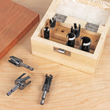 Woodworking plug cutter set in wooden box on workbench with four cutters displayed