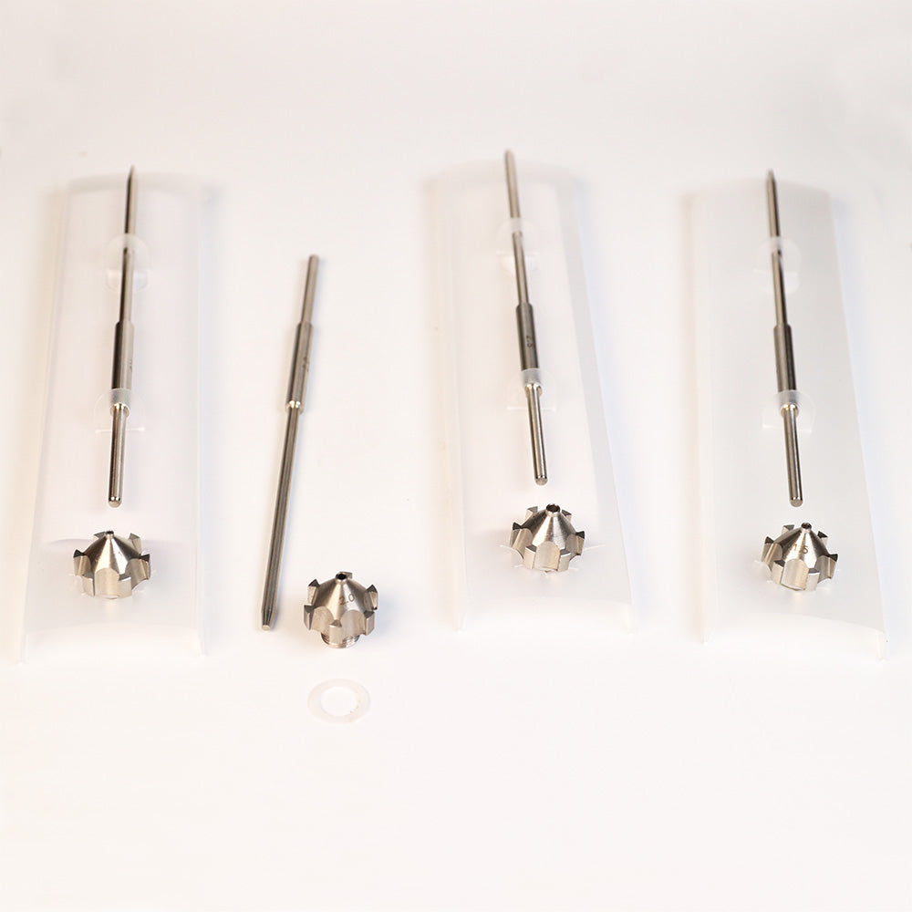 Set of four metal woodworking router bits with pointed tips and fluted ends on white background