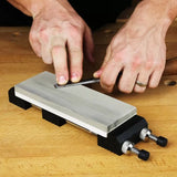 Sharpening a chisel on a sharpening stone with adjustable holder on a wooden workbench
