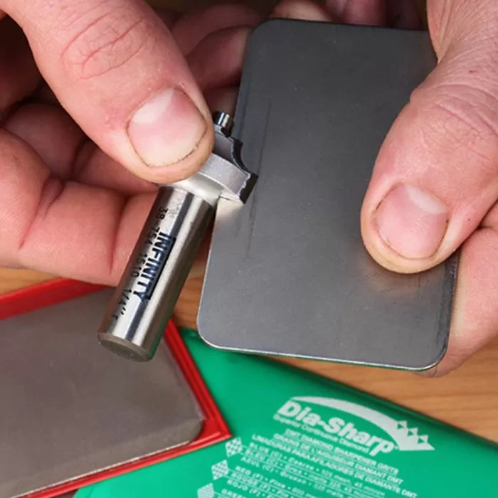 Person sharpening a router bit on a diamond sharpening plate for woodworking tools
