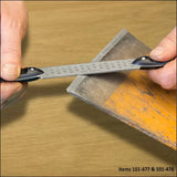 Hands sharpening a woodworking chisel with a diamond honing file on a workbench.